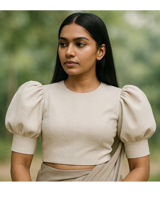 “Puff‑sleeve blouse with structured rounded sleeves, soft volume at the shoulders, fitted bodice, back